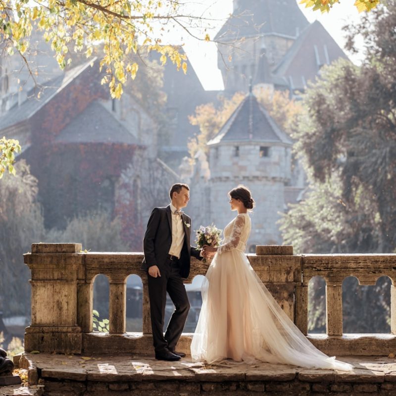 woman in white wedding dress stands in front of man in tuxedo