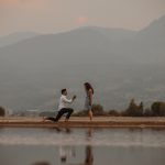 man in white shirt and black pants sitting on brown wooden dock during daytime